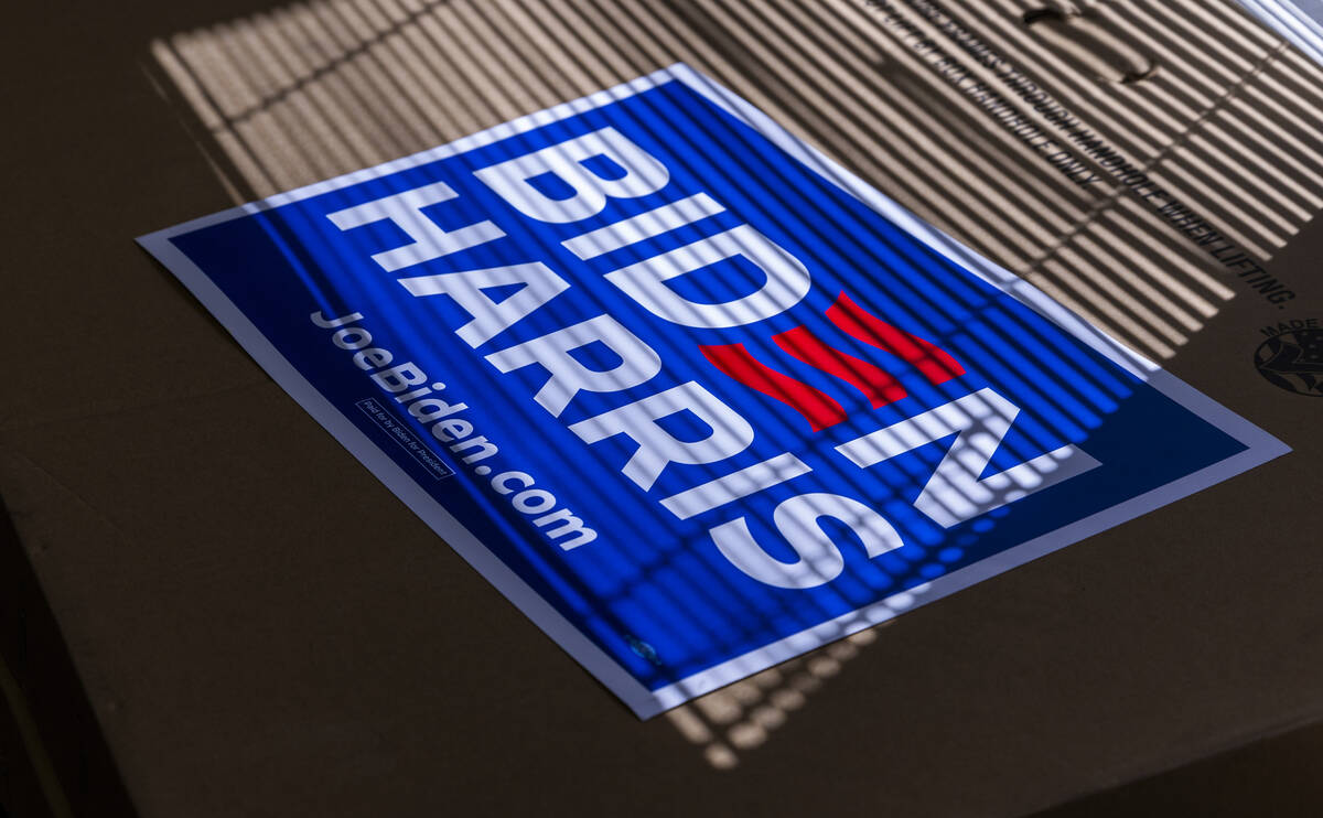 A Biden-Harris sign catches the window light atop a box of many more during a press conference ...
