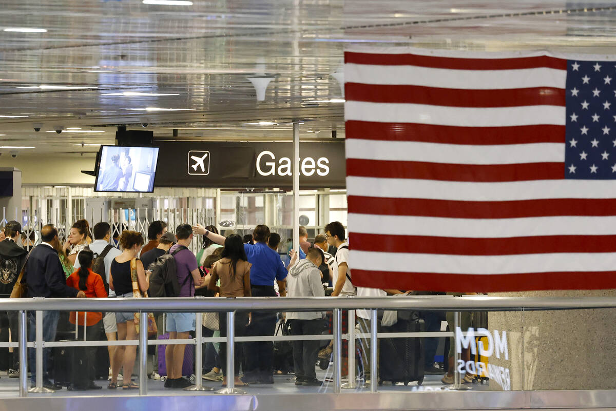 Departing passengers wait in line for security screening at Terminal-1 of Harry Reid Internatio ...