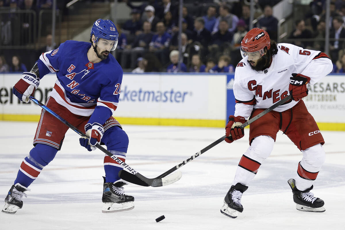 New York Rangers left wing Chris Kreider and Carolina Hurricanes defenseman Jalen Chatfield bat ...
