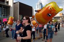 Protesters carry Trump balloons. (AP Photo/Gary Landers)