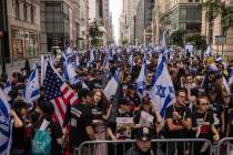 People hold Israeli flags as they gather ahead of the annual Israel Day Parade on Fifth Avenue ...