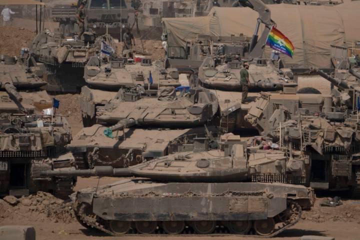 Israeli soldiers stand on top of tanks in a staging area near the Israeli-Gaza border in southe ...