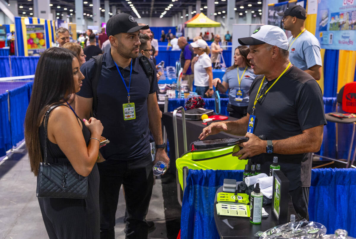 Richard Eklund with Bear Lake Pickleball, right, talks about their paddle cleaning product to a ...
