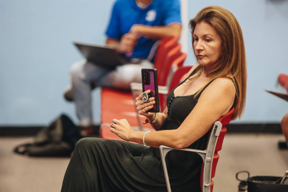 An attendee livestreams from their phone during a meeting hosted by CCSD officials at Indian Sp ...