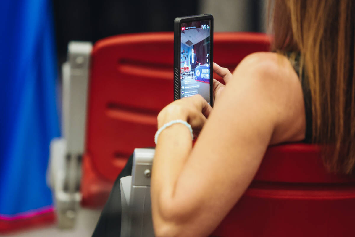 An attendee livestreams from their phone during a meeting hosted by CCSD officials at Indian Sp ...
