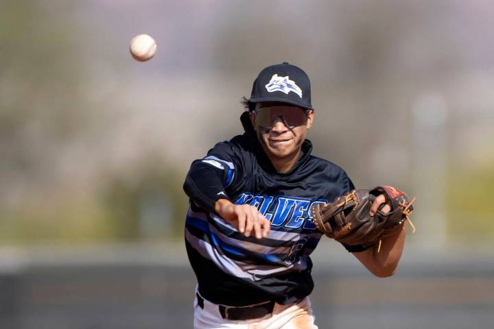 Basic’s Tate Southisene throws to first base for an out on Coronado during a high school ...