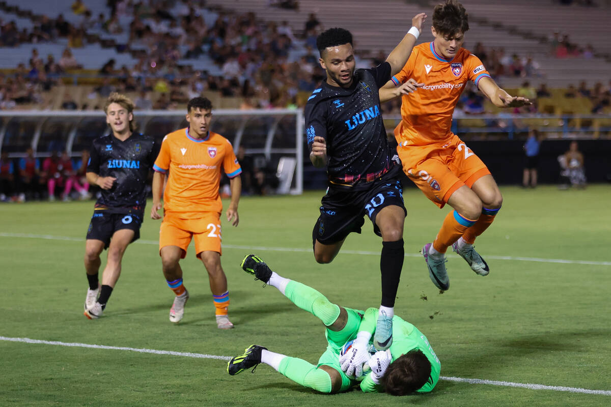 Las Vegas Lights FC defender Shawn Smart (20) and Miami FC defender Alejandro Mitrano jump over ...