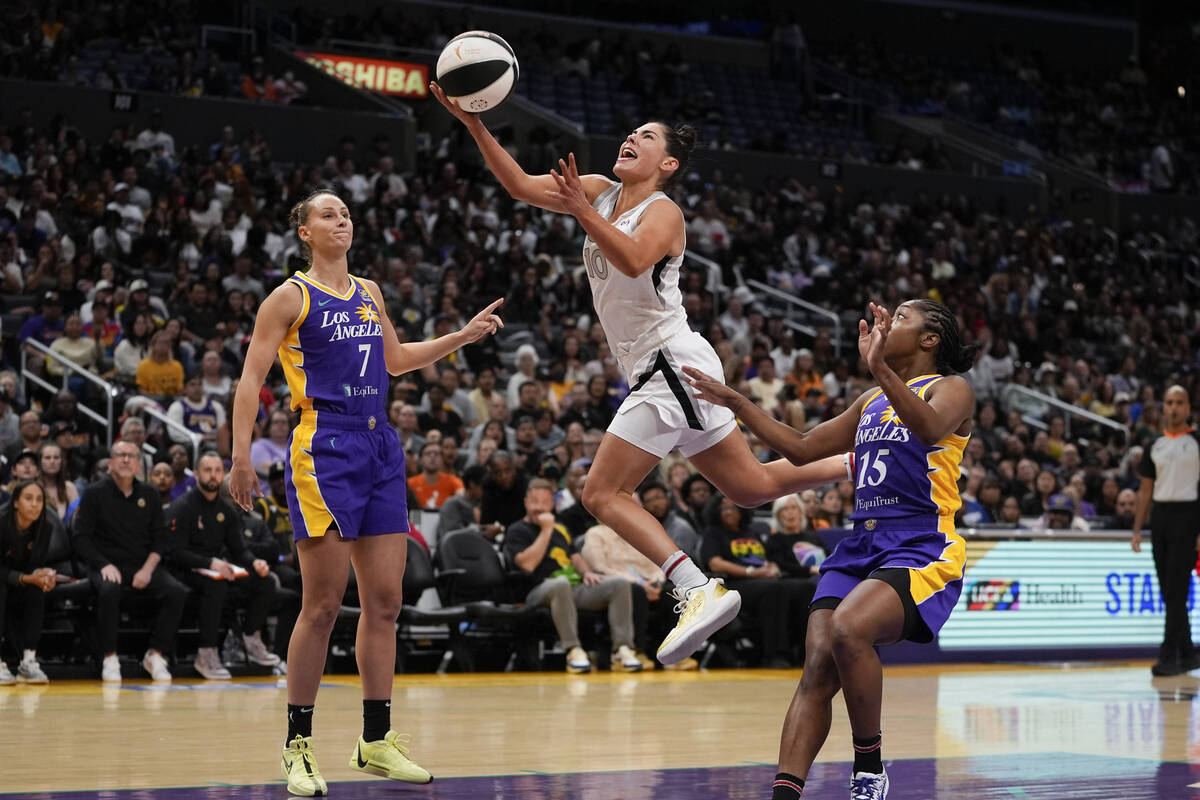 Las Vegas Aces guard Kelsey Plum, center, shoots against Los Angeles Sparks forward Stephanie T ...