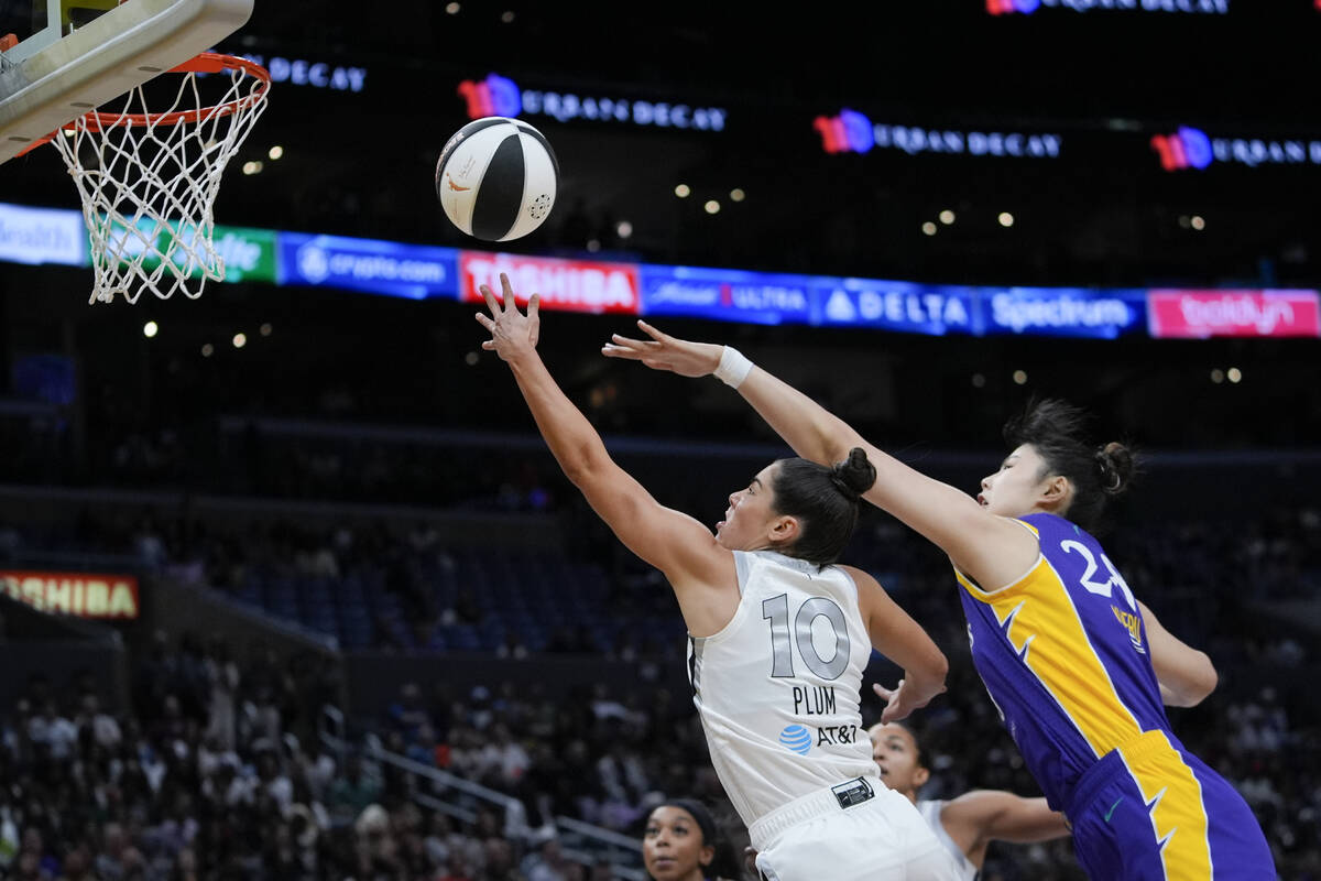 Las Vegas Aces guard Kelsey Plum, left, scores past Los Angeles Sparks center Li Yueru during t ...