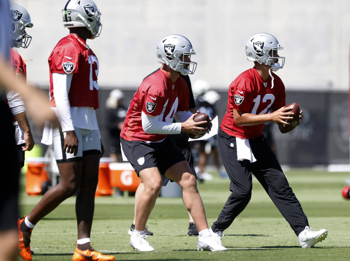 Raiders quarterbacks Carter Bradley (14) and Aidan O'Connell (12) prepare to throw the ball as ...