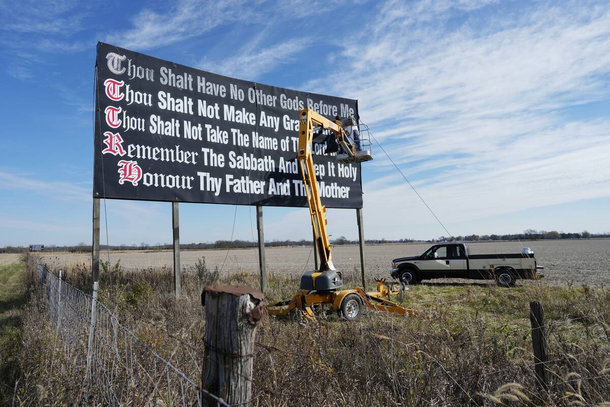 Workers repaint a Ten Commandments billboard off of Interstate 71 on Election Day near Chenowet ...