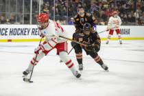 Boston University's Macklin Celebrini (71) skates with the puck in front of Rochester's Elijah ...