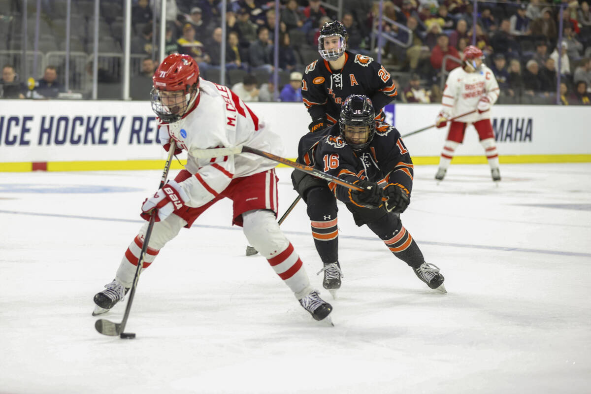 Boston University's Macklin Celebrini (71) skates with the puck in front of Rochester's Elijah ...