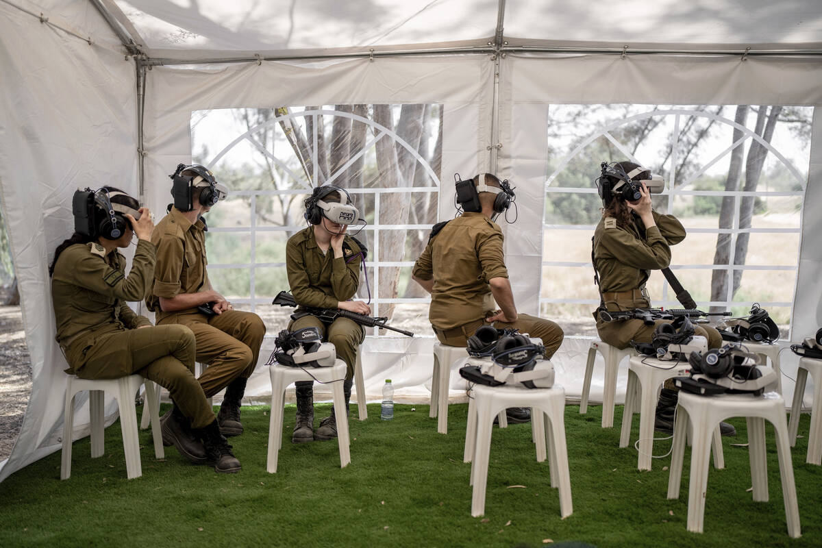 Israeli soldiers watch a virtual tour of the destruction of the aftermath of the Oct. 7 Hamas a ...