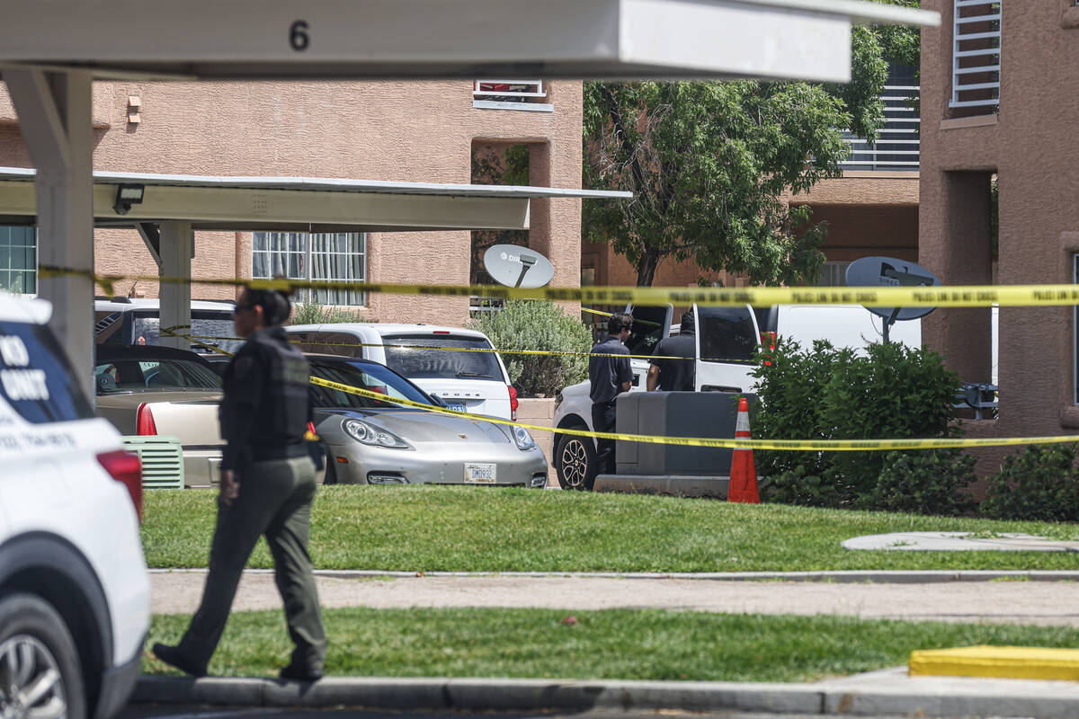 North Las Vegas police investigate the scene where five people were found dead in an apartment ...
