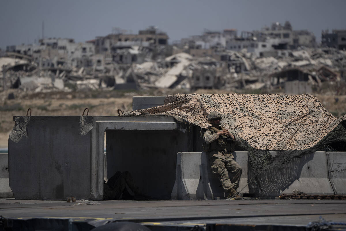 A U.S. Army soldier stands next to a shelter at the U.S.-built floating pier Trident backdroppe ...