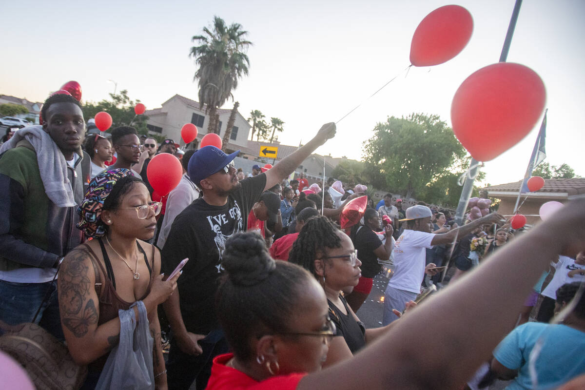 Red balloons are released into the sky during a candlelight service for Kayla Harris at Craig R ...
