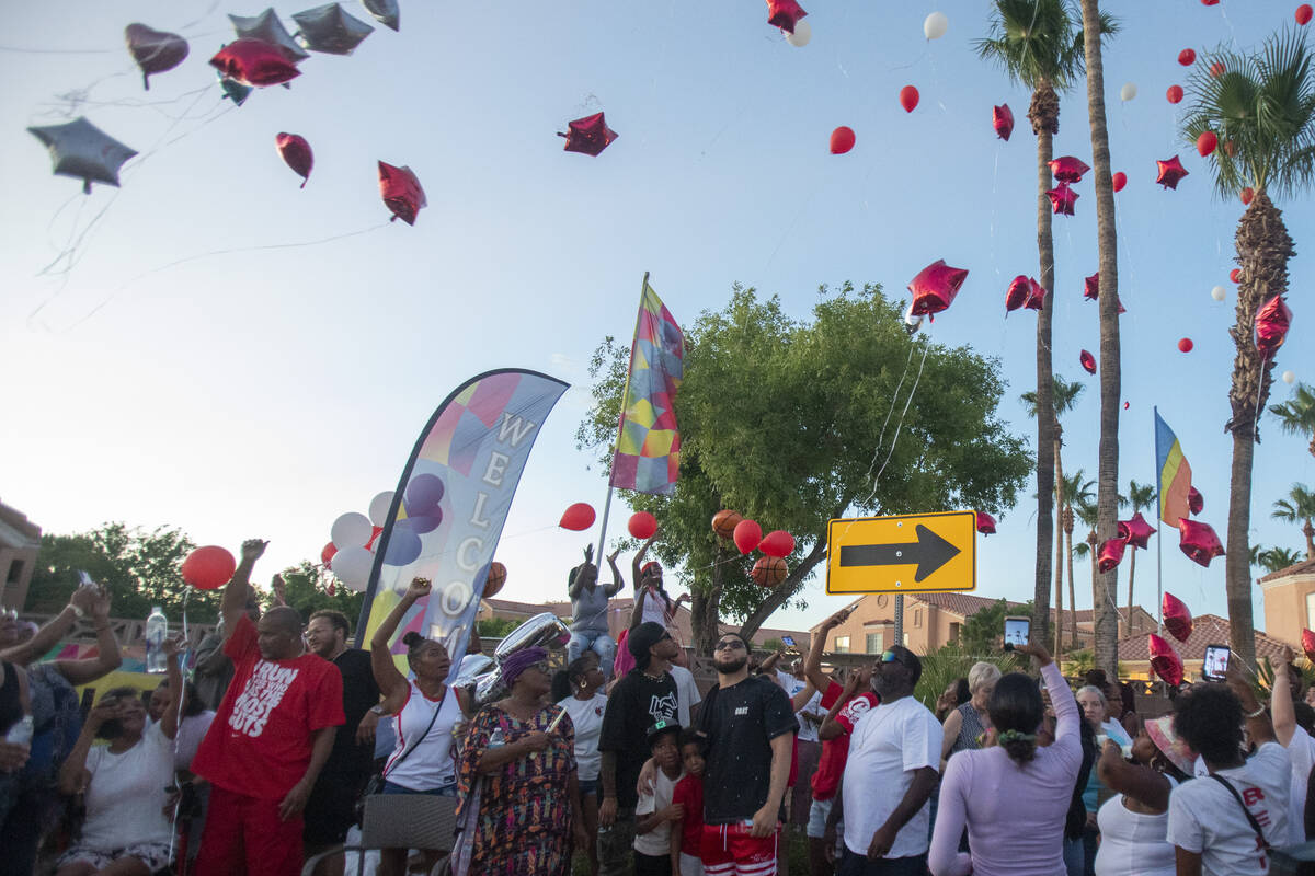 Red balloons are released into the sky during a candlelight service for Kayla Harris at Craig R ...