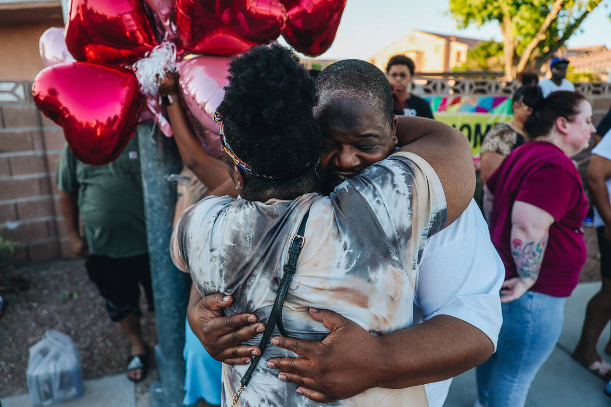 Mourners hug during a vigil for Kayla Harris, who was killed in a quintuple homicide on June 24 ...