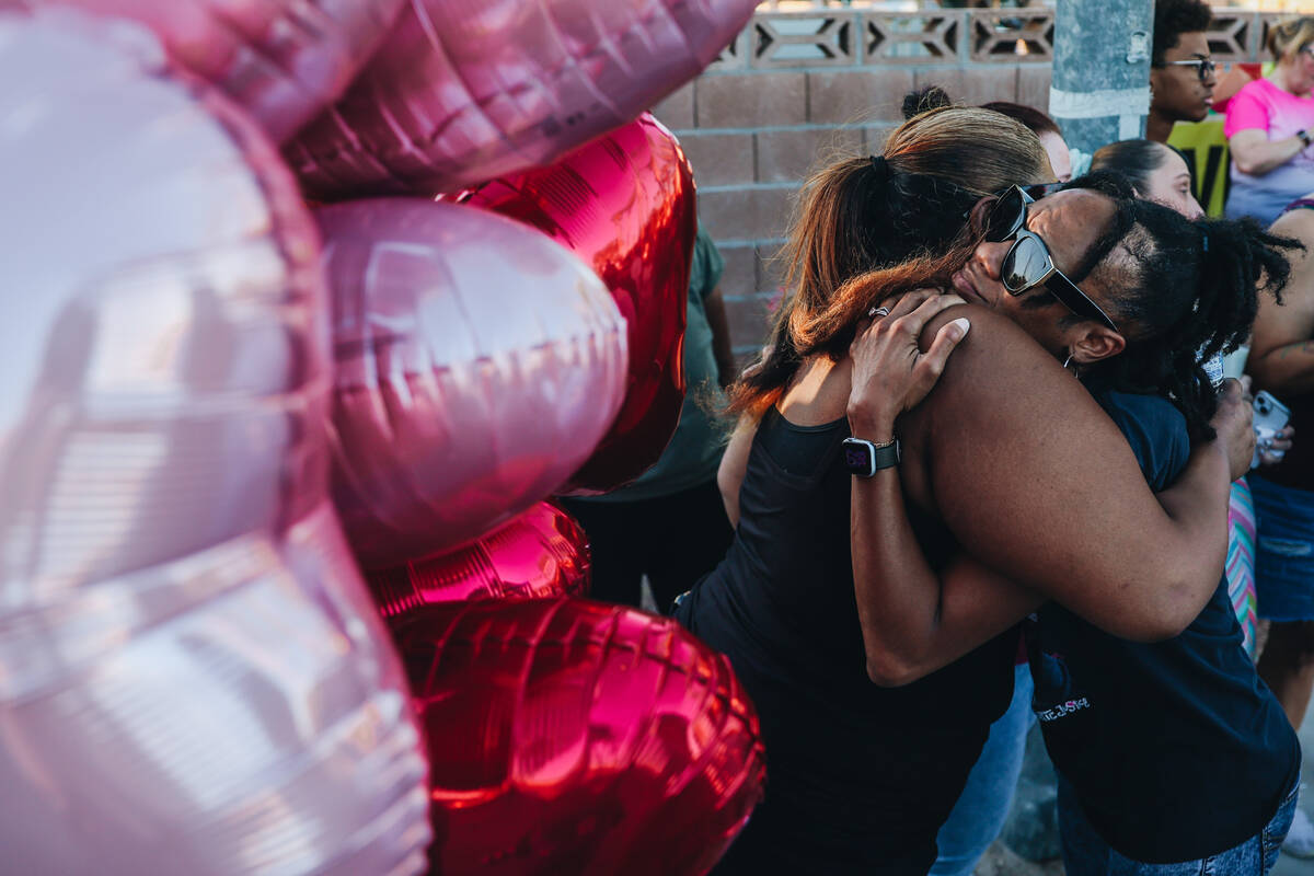 Mourners hug during a vigil for Kayla Harris, who was killed in a quintuple homicide on June 24 ...