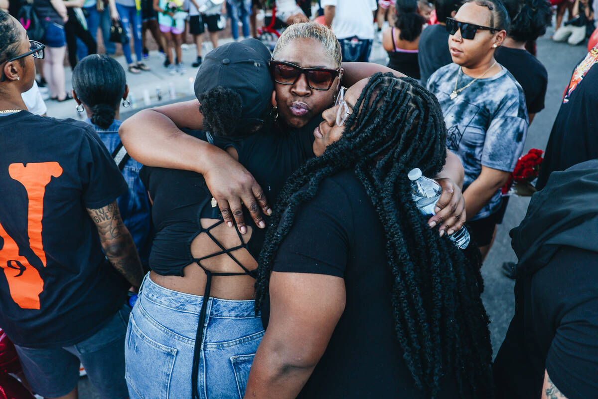 Mourners hug during a vigil for Kayla Harris, who was killed in a quintuple homicide on June 24 ...