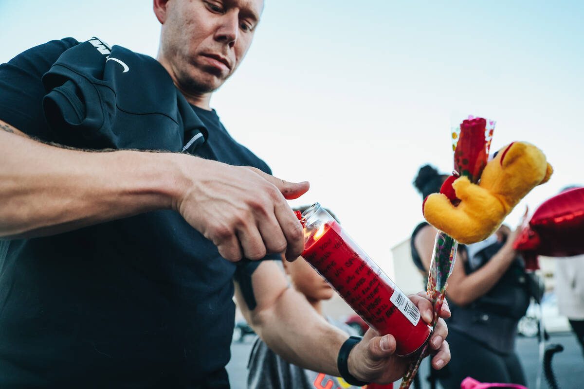A mourner lights a candle during a vigil for Kayla Harris, who was killed in a quintuple homici ...