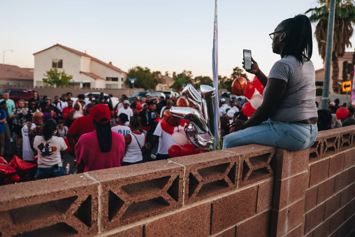 A mourner films with a cell phone during a vigil for Kayla Harris, who was killed in a quintupl ...