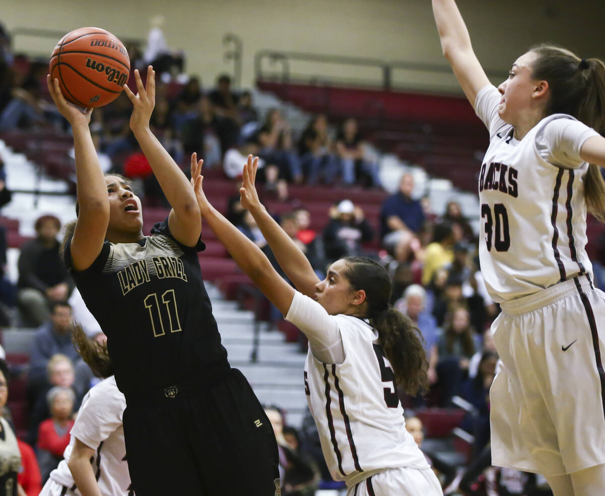 Spring Valley's Kayla Harris (11) shoots over Desert Oasis' Eliyjah Pricebrooks (5) and Desert ...