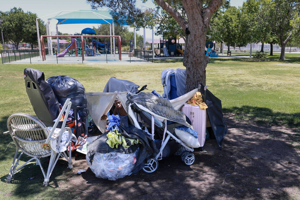 Nathalie Brown, 57, takes shelter from the sun with her belongings at Justice Myron E. Leavitt ...