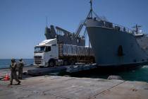 A U.S. Army soldier gestures as trucks loaded with humanitarian aid arrive at the U.S.-built fl ...