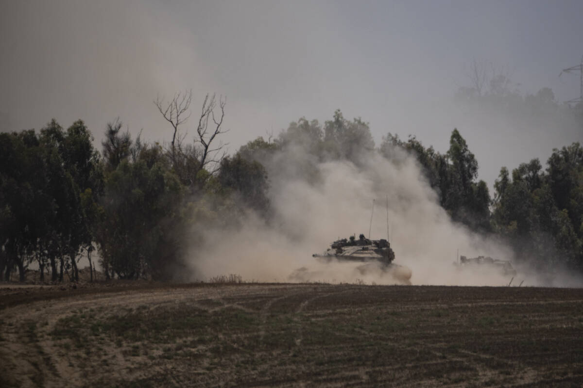 Israeli soldiers move on the top of a tank near the Israeli-Gaza border, as seen from southern ...