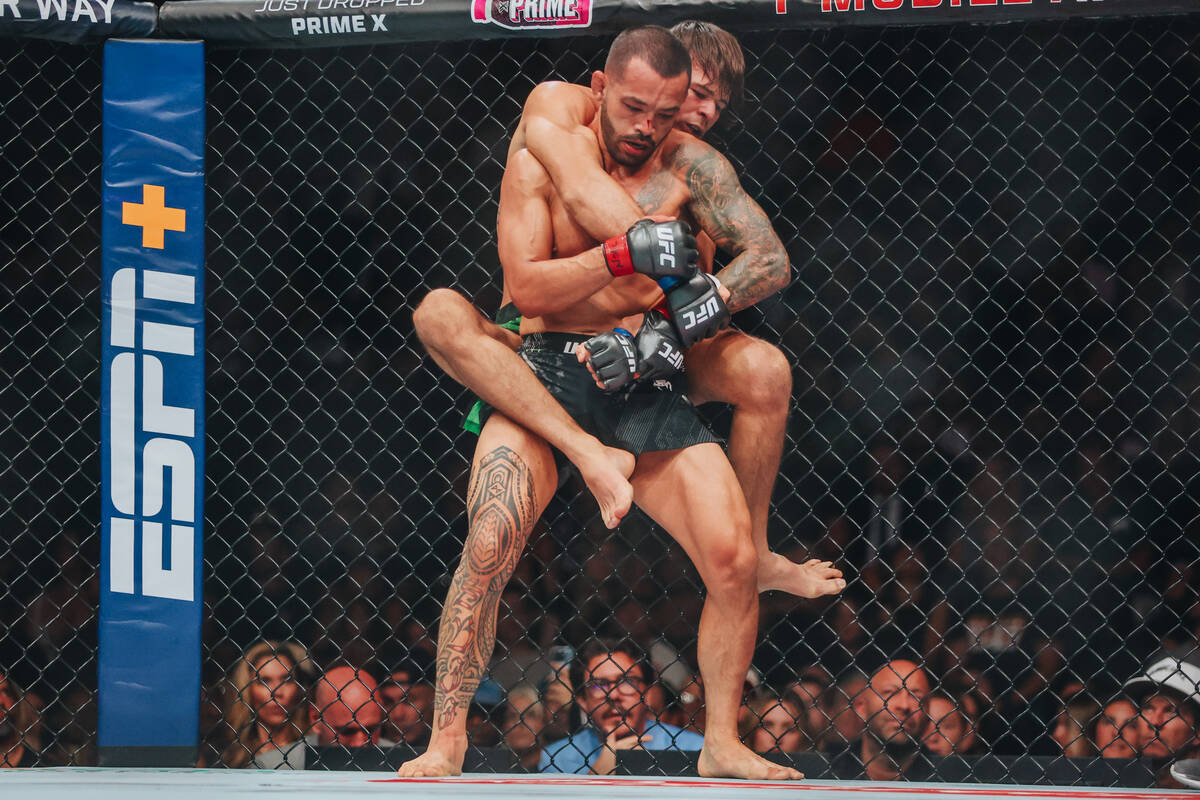 Diego Lopes jumps on Dan Ige’s back during their catchweight bout at UFC 303 at T-Mobile ...