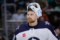 Winnipeg Jets goaltender Laurent Brossoit (39) on the ice with his helmet tipped back waiting f ...