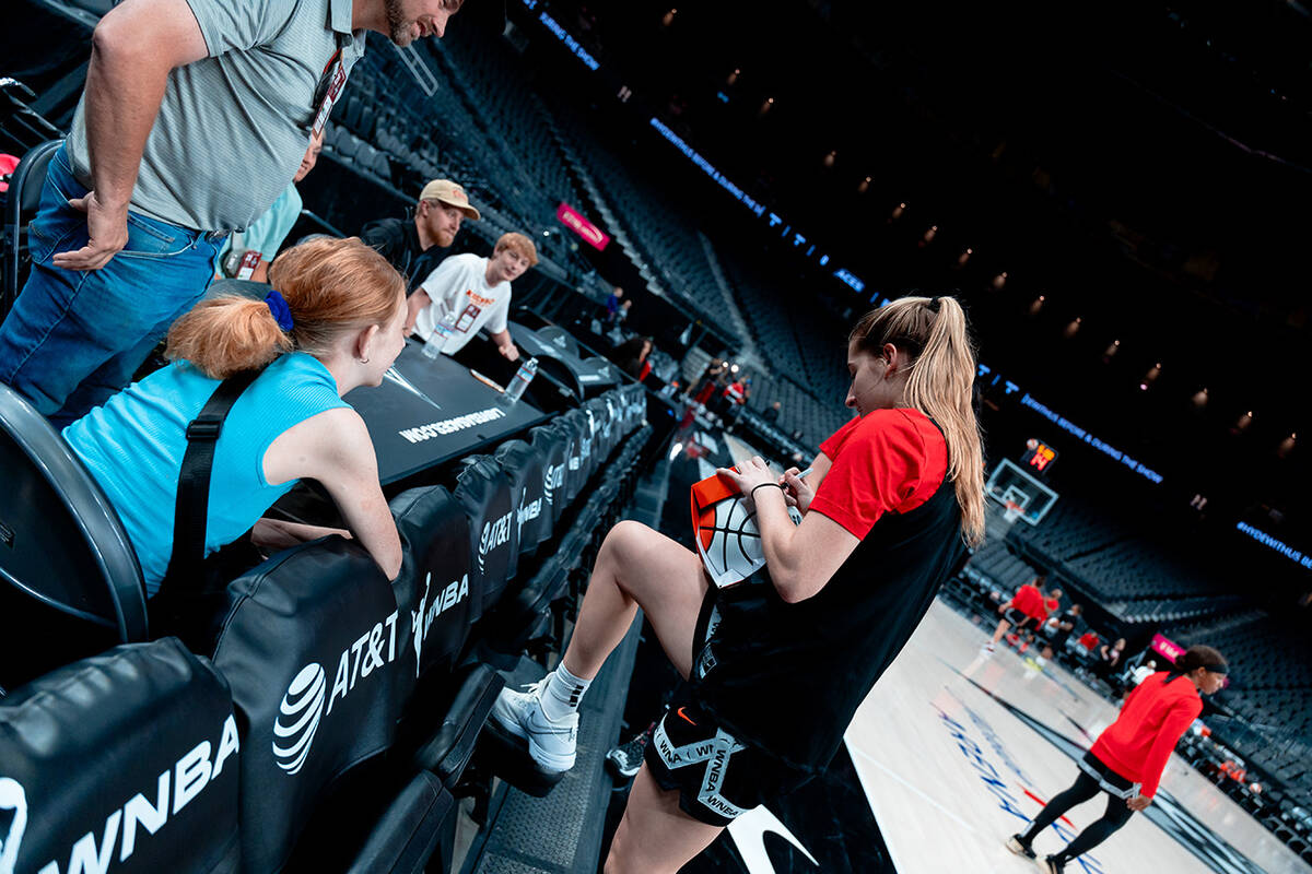 Las Vegas Aces rookie guard Kate Martin signs WNBA basketball for Bailey Lux during practice Mo ...