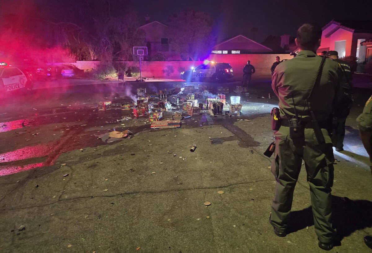Las Vegas Fire Department firefighters and other officials shine lights on a large display of i ...