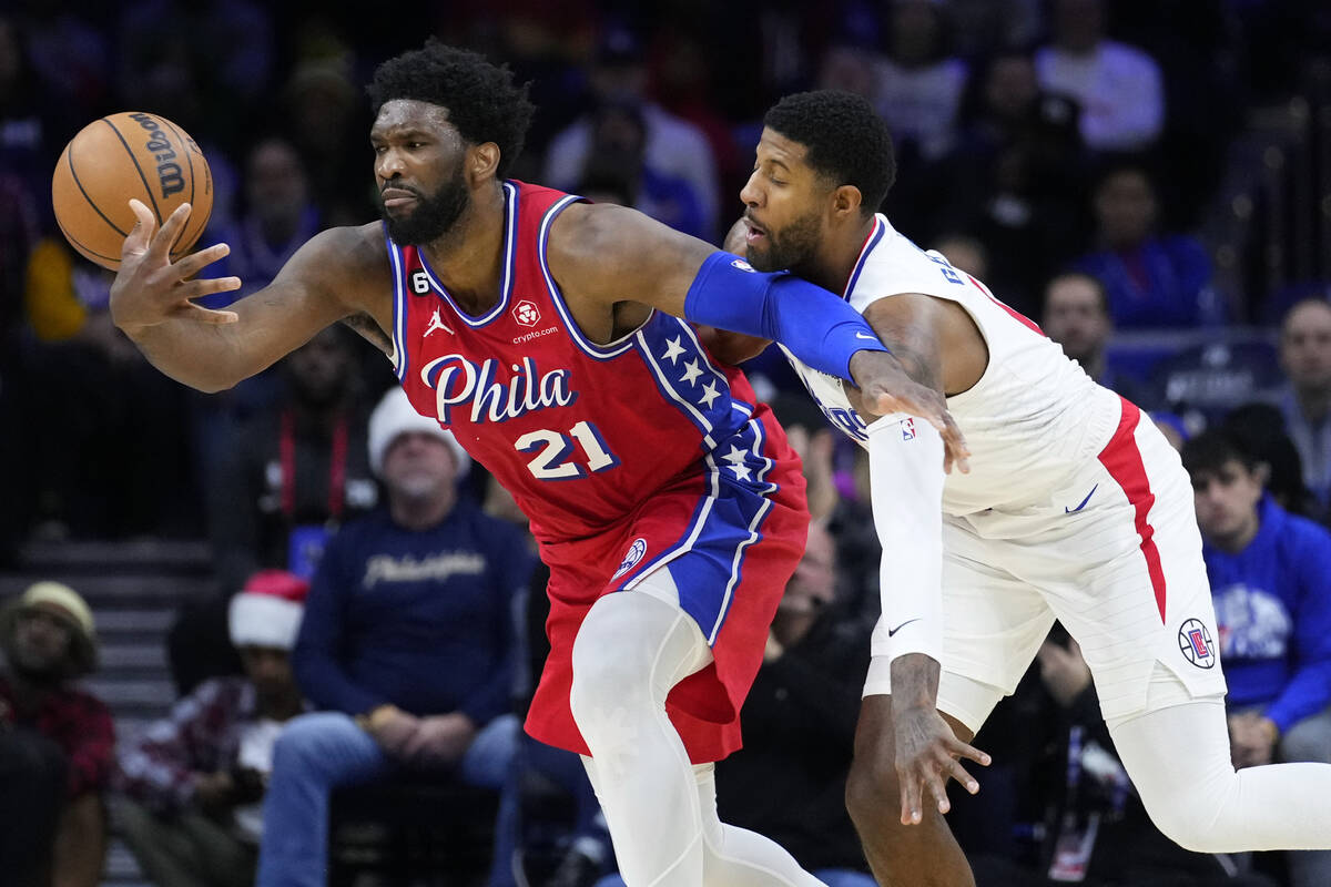FILE - Philadelphia 76ers' Joel Embiid, left, tries to hang onto the ball against Los Angeles C ...