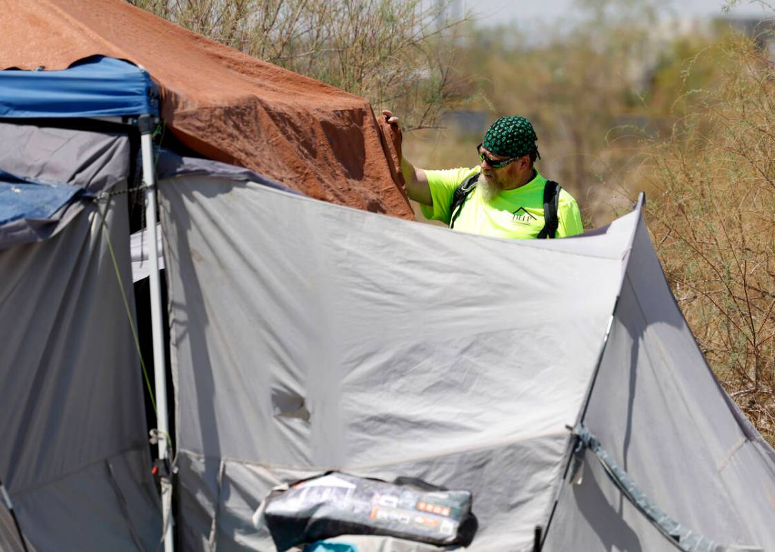 Chris Engel, a Help of Southern Nevada outreach worker, speaks to homeless people after deliver ...