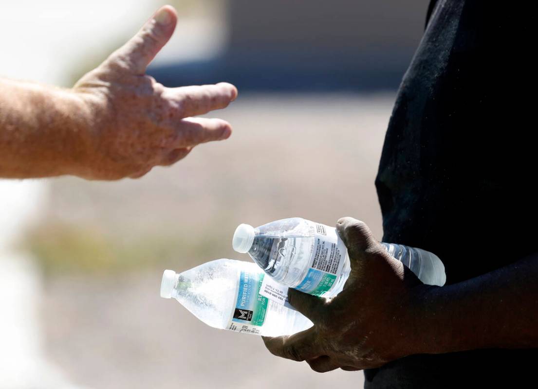 Darryl Walker, right, a homeless, talks to a Help of Southern Nevada outreach worker near Mount ...