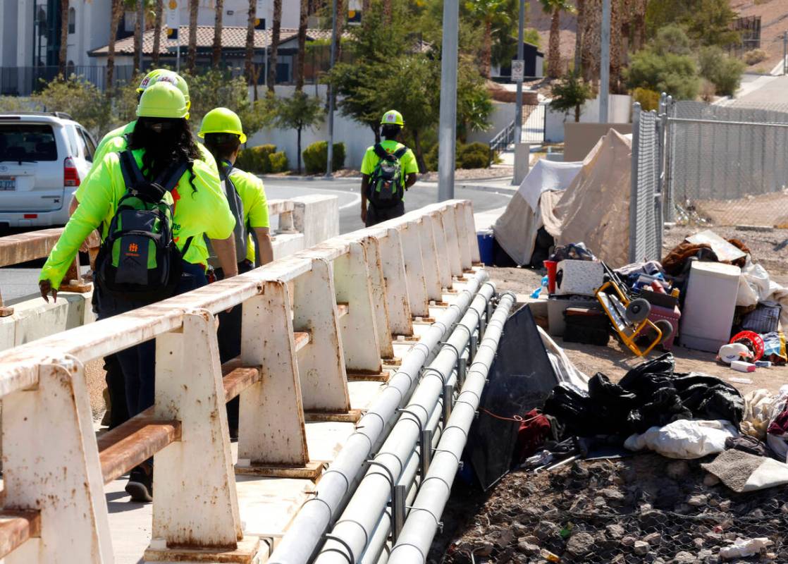 A Help of Southern Nevada outreach workers cross the bridge to check out homeless people near M ...