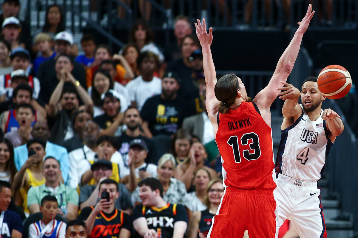 USA guard Stephen Curry (4) passes up the court while Canada center Kelly Olynyk (13) defends d ...