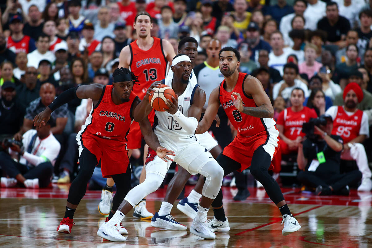 USA center Bam Adebayo (13) maneuvers through defense by Canada guard Luguentz Dort (0) and Can ...