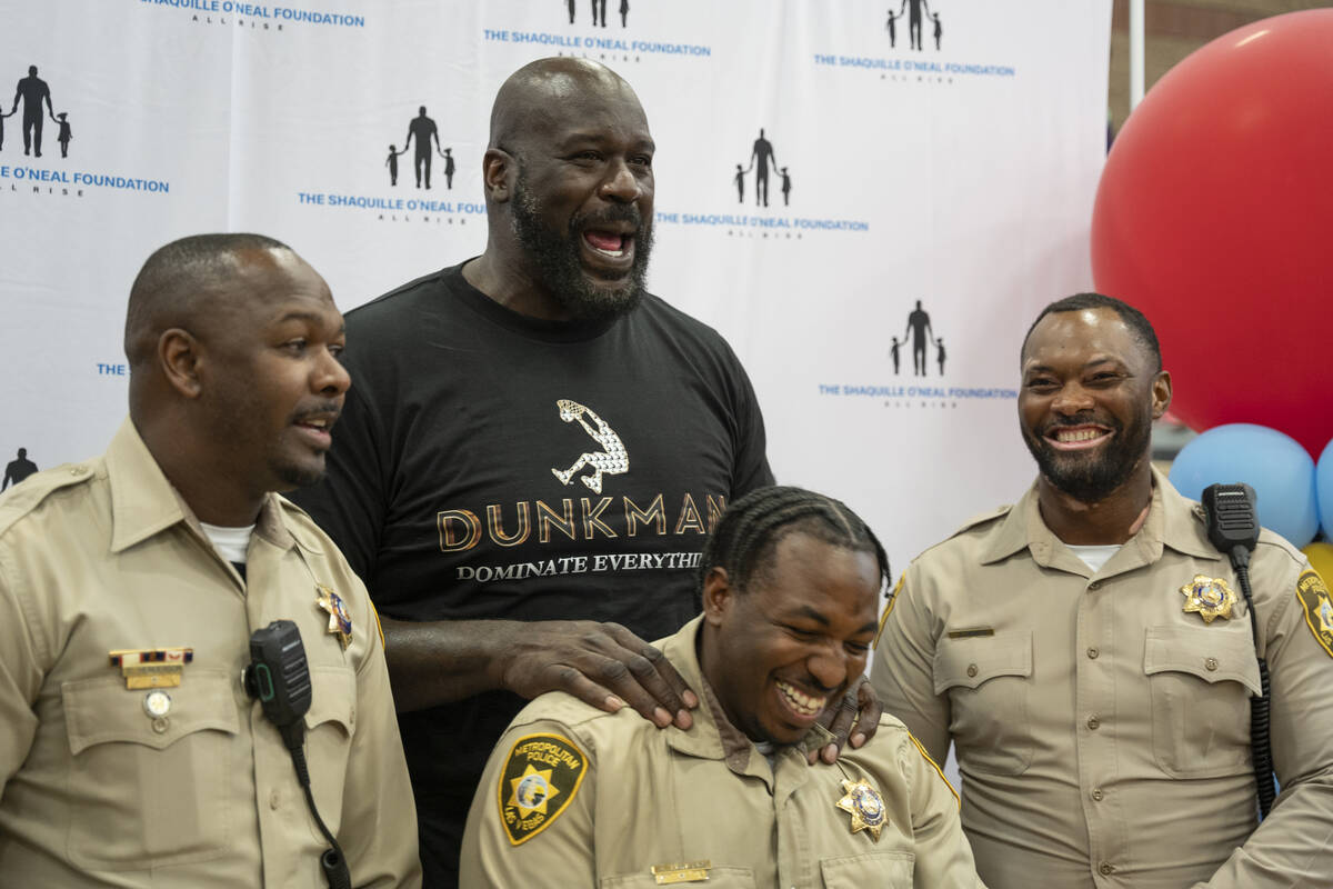 Shaquille O'Neal jokes with LVMPD officers at the Shaq-to-School event in the Mario C. & Jo ...