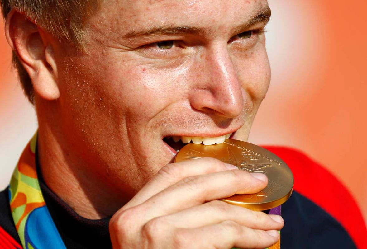 FILE - Connor Fields, of the United States, bites his gold medal during a victory ceremony for ...