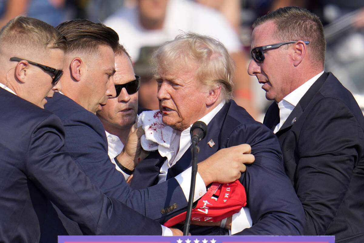 Republican presidential candidate former President Donald Trump is helped off the stage at a ca ...