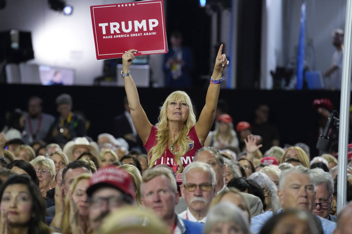 A delegate holds up a sign during the Republican National Convention Monday, July 15, 2024, in ...