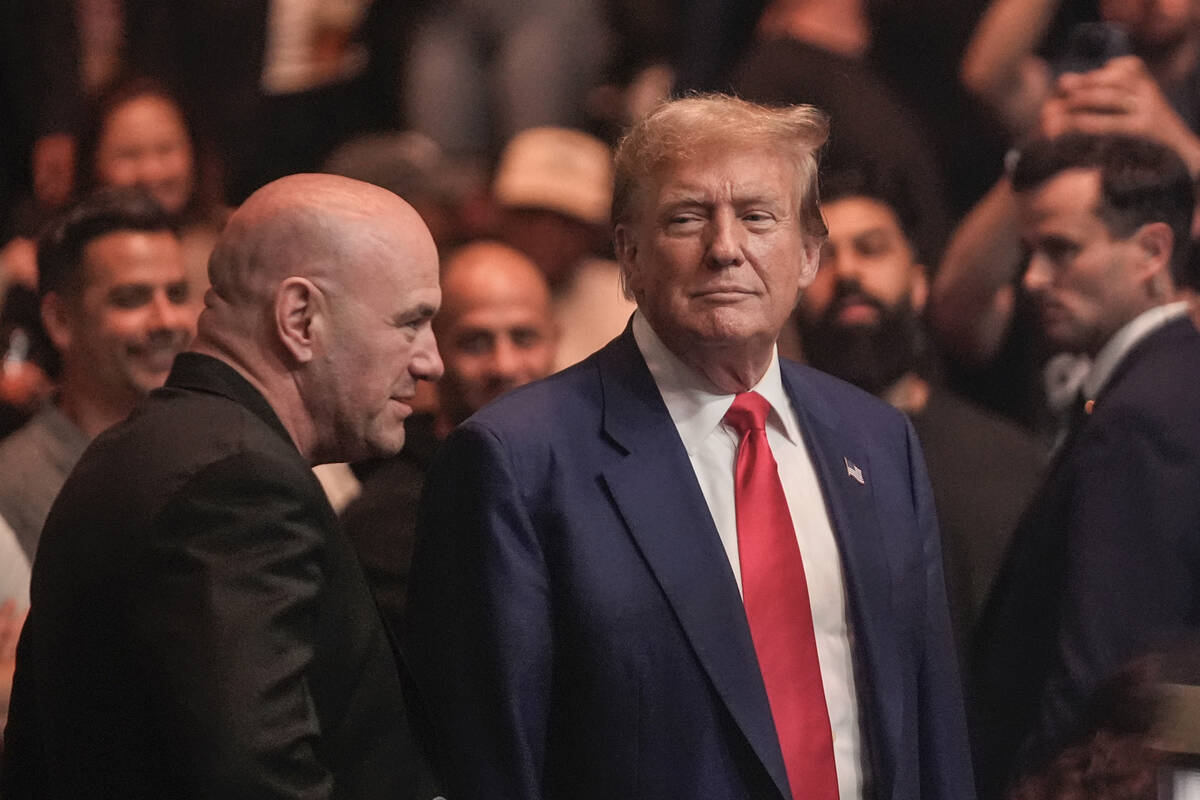 Former President Donald Trump, right, talks to Dana White while attending the UFC 302 mixed mar ...