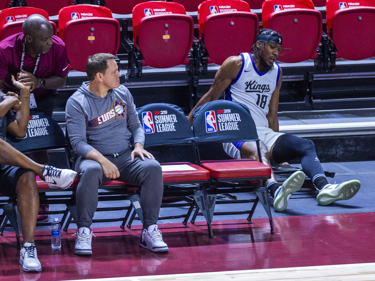 Sacramento Kings forward Xavier Sneed (18) crashes over the sideline chairs after a push from t ...