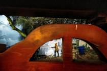 A firefighter hoses down the garage of Noel Piri's home that was destroyed by the Hawarden Fire ...