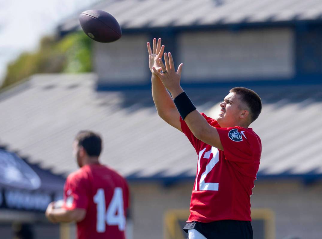 Raiders quarterback Aidan O'Connell (12) catches the ball during the first day of training camp ...