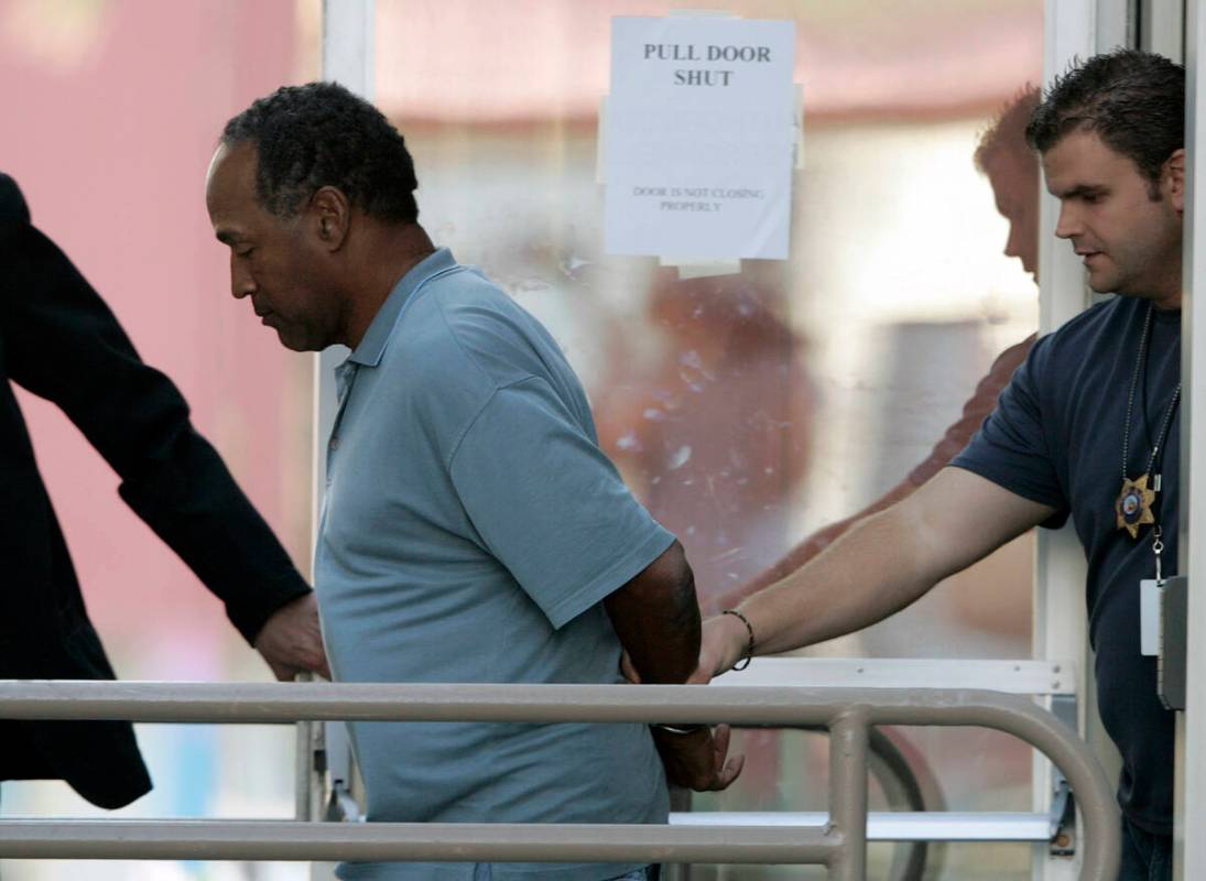 O.J. Simpson is taken from the Las Vegas Police Investigative Services Division in Las Vegas in ...